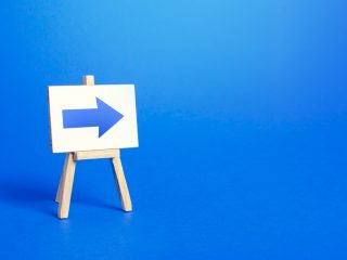Easel with a blue right arrow. Sign of direction. Advertising of the location of a store or outlet. Easel with a blue right arrow. Sign of direction. Advertising of the location of a store or outlet.